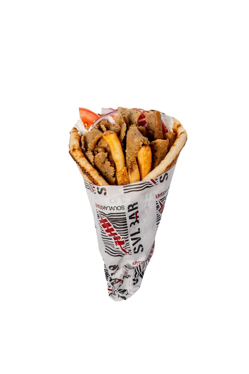 A gyros pita wrap, filled with meat, fries, tomatoes, and onions, wrapped in branded paper.